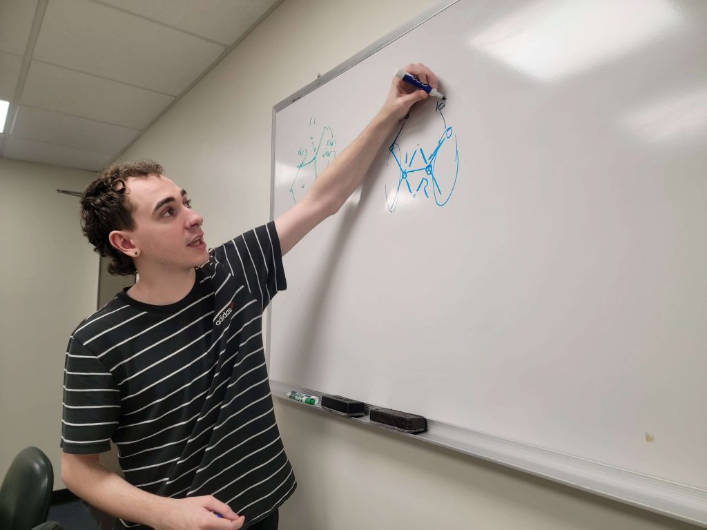 Cody drawing on a whiteboard.