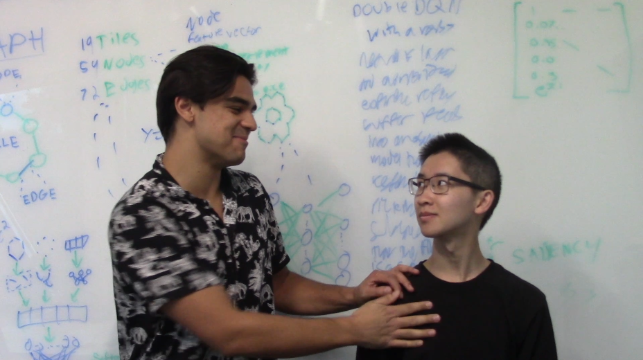 Andres and Jason standing in front of a whiteboard and speaking to the camera.